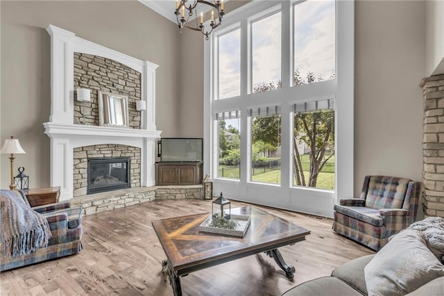 25203 W 97th Ter, Lenexa, KS 66227 - living area with a towering ceiling, a stone fireplace, a chandelier, and wood finished floors