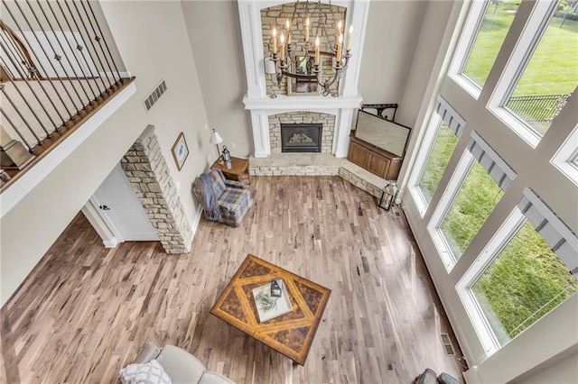 25203 W 97th Ter, Lenexa, KS 66227 - living room featuring a high ceiling, wood finished floors, a fireplace, a chandelier, and baseboards