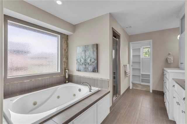 25203 W 97th Ter, Lenexa, KS 66227 - full bath featuring a whirlpool tub, a shower stall, baseboards, and vanity