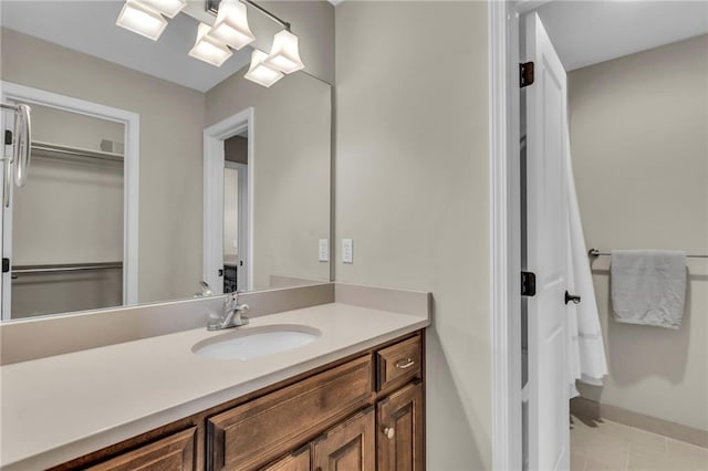25203 W 97th Ter, Lenexa, KS 66227 - bathroom with vanity, tile patterned floors, a walk in closet, and baseboards