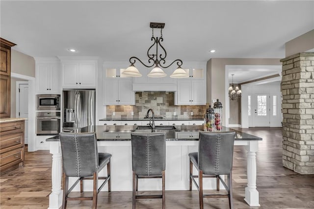 25203 W 97th Ter, Lenexa, KS 66227 - kitchen featuring appliances with stainless steel finishes, dark countertops, glass insert cabinets, dark wood-style flooring, and decorative backsplash