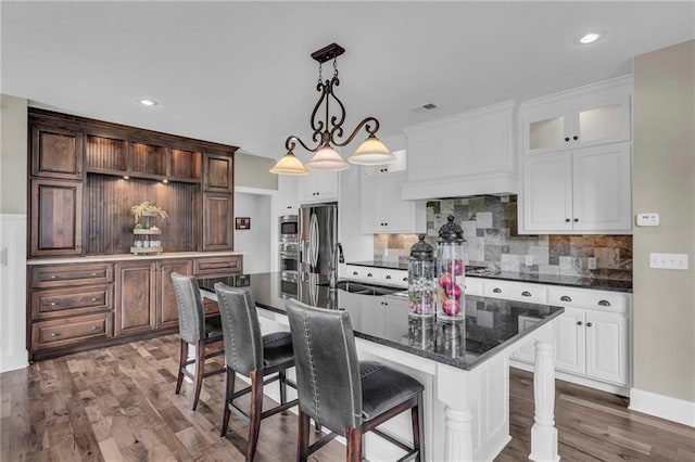 25203 W 97th Ter, Lenexa, KS 66227 - kitchen featuring a sink, appliances with stainless steel finishes, tasteful backsplash, a kitchen breakfast bar, and dark wood-style floors