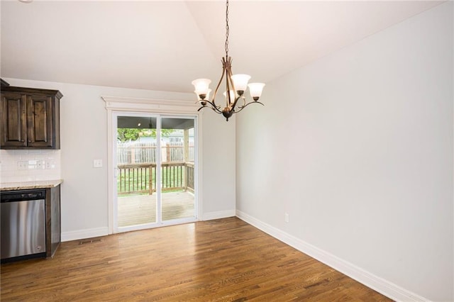 unfurnished dining area with an inviting chandelier, baseboards, vaulted ceiling, and wood finished floors