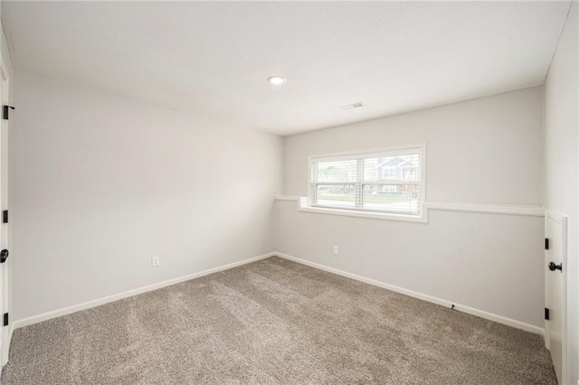 spare room featuring baseboards, carpet, recessed lighting, and visible vents