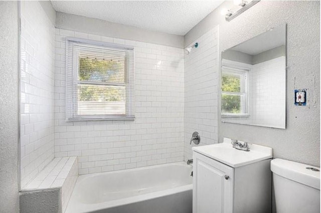 2922 Bales Ave, Kansas City, MO 64128 - bathroom featuring toilet, washtub / shower combination, a wealth of natural light, and vanity