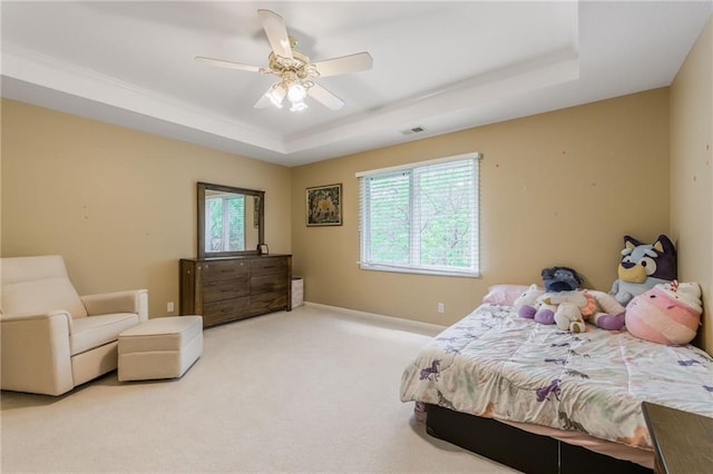 bedroom with a raised ceiling, carpet, multiple windows, and ceiling fan