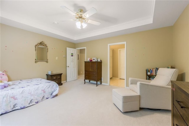bedroom with a raised ceiling, light colored carpet, baseboards, and a ceiling fan