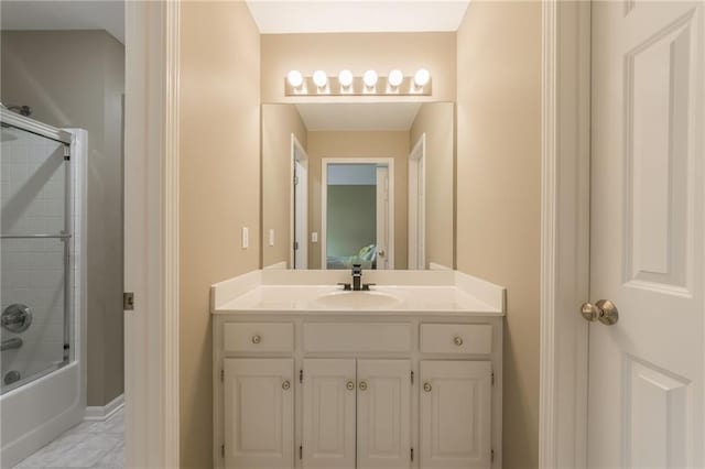 full bath featuring vanity, shower / bath combination with glass door, tile patterned flooring, and baseboards