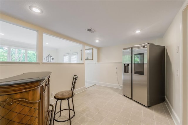 kitchen featuring stainless steel fridge with ice dispenser, baseboards, healthy amount of natural light, and recessed lighting