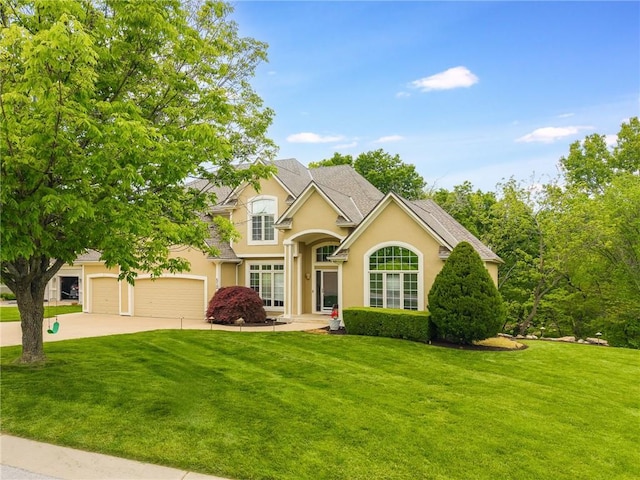 view of front of property featuring a front lawn, stucco siding, and driveway