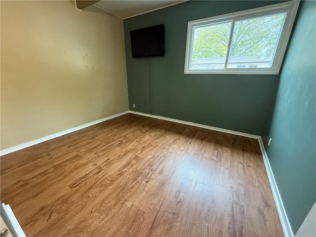 unfurnished room with baseboards and wood finished floors