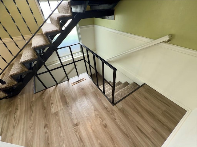 staircase featuring baseboards and wood finished floors