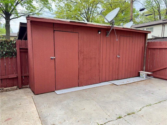 view of shed featuring fence
