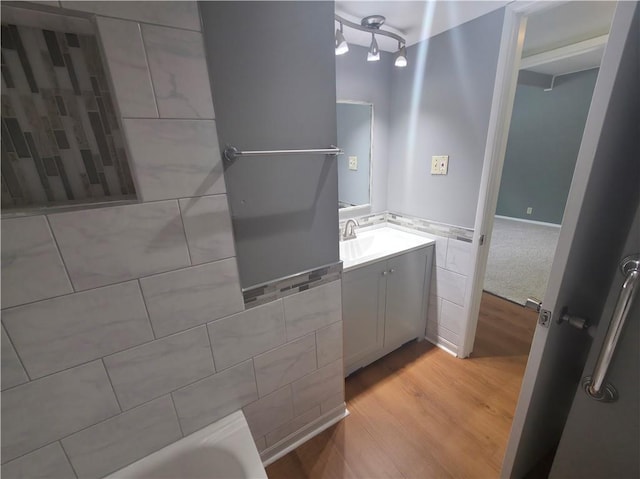 919 N 70th Ter, Kansas City, KS 66112 - bathroom with vanity, wood finished floors, and a tub