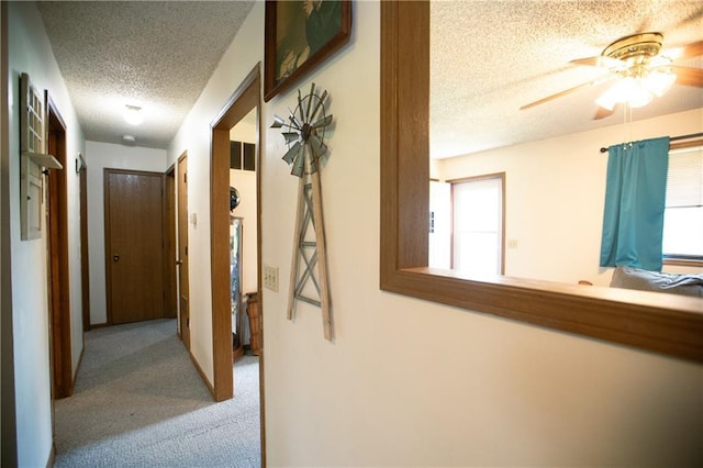 hallway featuring a textured ceiling and carpet flooring
