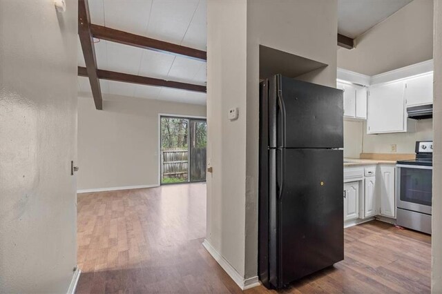 kitchen with stainless steel electric range oven, wood finished floors, freestanding refrigerator, beamed ceiling, and range hood