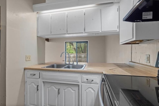 kitchen with a sink, white cabinets, under cabinet range hood, and light countertops