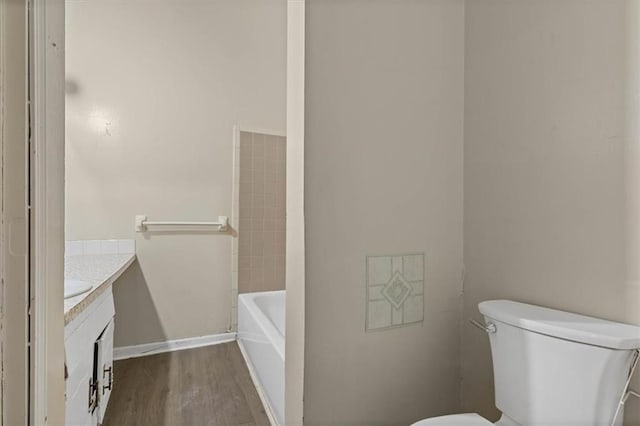 bathroom with vanity, a tub to relax in, toilet, a shower, and wood finished floors