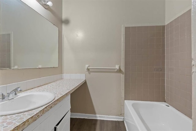bathroom with wood finished floors, vanity, and baseboards