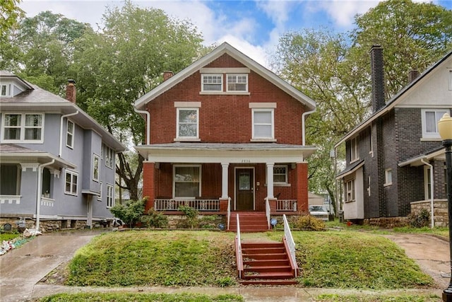 traditional style home featuring brick siding, a porch, and a front lawn