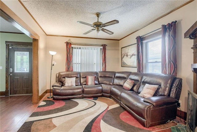 living room with ornamental molding, ceiling fan, a textured ceiling, and wood finished floors