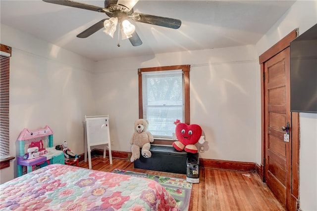 bedroom featuring baseboards, hardwood / wood-style flooring, and ceiling fan