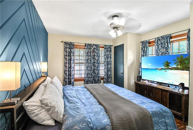 bedroom featuring wood finished floors and multiple windows