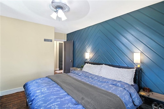 bedroom with visible vents, ceiling fan, wood finished floors, and baseboards