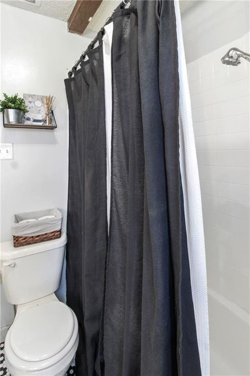 bathroom with shower / bathtub combination with curtain and toilet