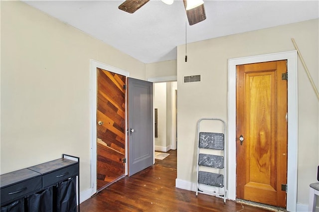 corridor featuring visible vents, wood finished floors, and baseboards