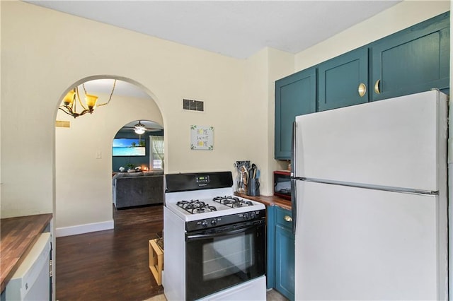 kitchen featuring arched walkways, freestanding refrigerator, wood counters, visible vents, and range with gas stovetop