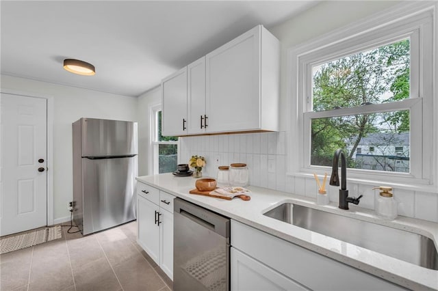 kitchen featuring a healthy amount of sunlight, appliances with stainless steel finishes, decorative backsplash, and a sink