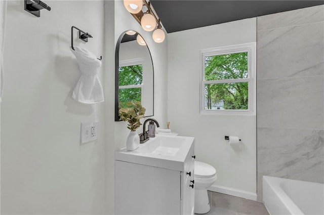bathroom featuring tile patterned flooring, toilet, a bathtub, vanity, and baseboards
