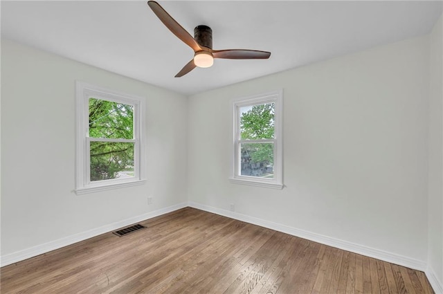 empty room with visible vents, plenty of natural light, and baseboards