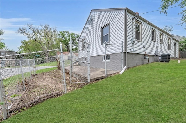 view of side of home with a gate, fence, central air condition unit, and a lawn