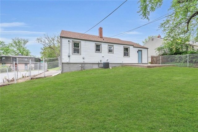 rear view of property with a lawn, central AC unit, a fenced backyard, and a chimney