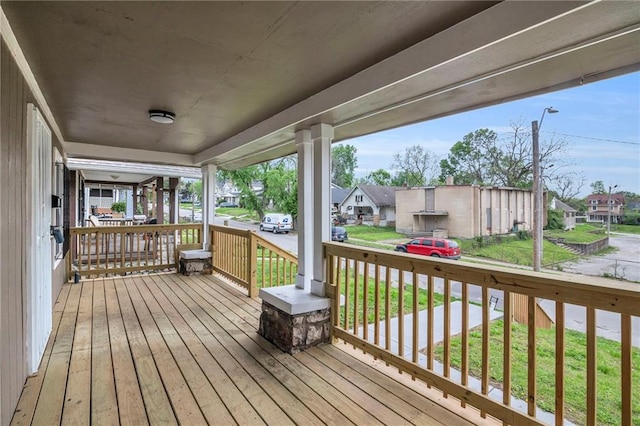 wooden deck with covered porch and a residential view