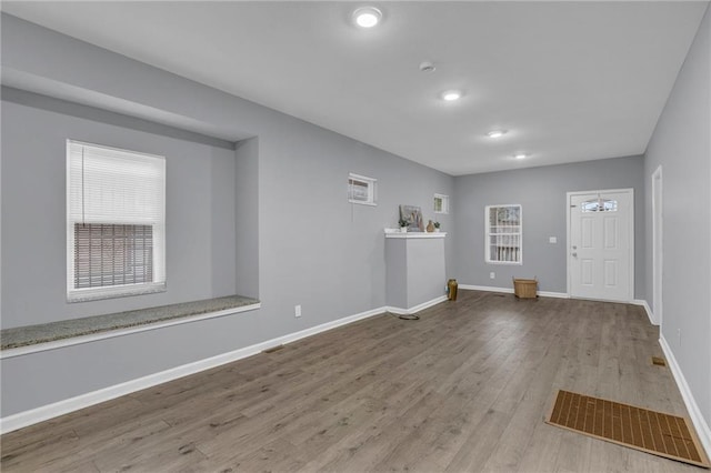 unfurnished living room with baseboards, recessed lighting, wood finished floors, and visible vents