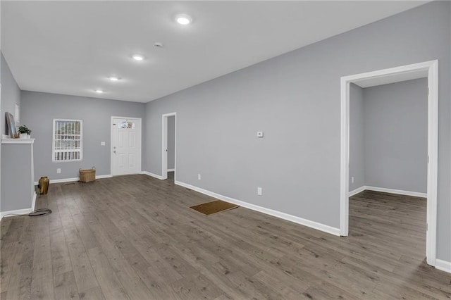unfurnished living room with baseboards, recessed lighting, and wood finished floors
