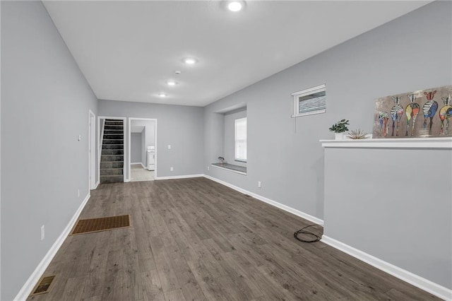 unfurnished living room featuring visible vents, wood finished floors, baseboards, stairway, and recessed lighting