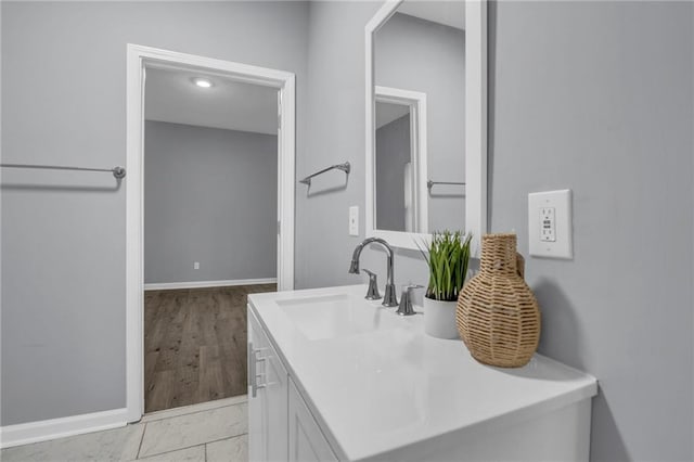 bathroom with baseboards, marble finish floor, and vanity