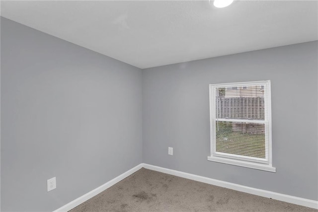 unfurnished room featuring carpet floors and baseboards