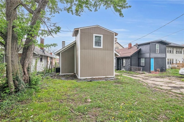 back of house with an outbuilding and a yard