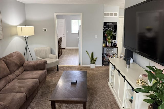 living room with carpet flooring, baseboards, and visible vents