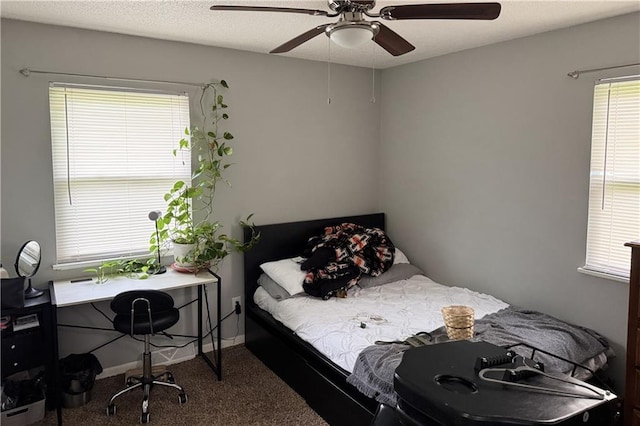 bedroom with a ceiling fan, multiple windows, and carpet flooring