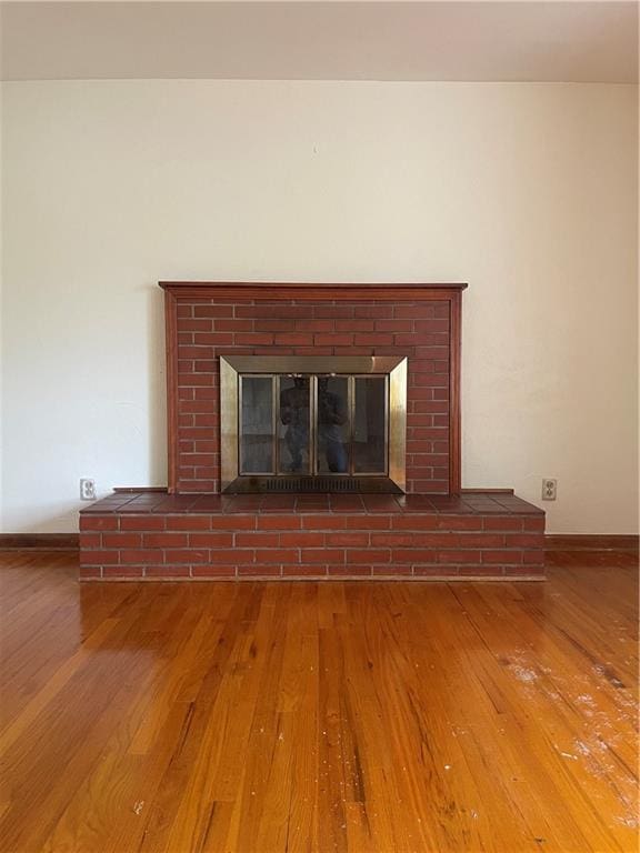 interior details with baseboards, a fireplace, and wood finished floors