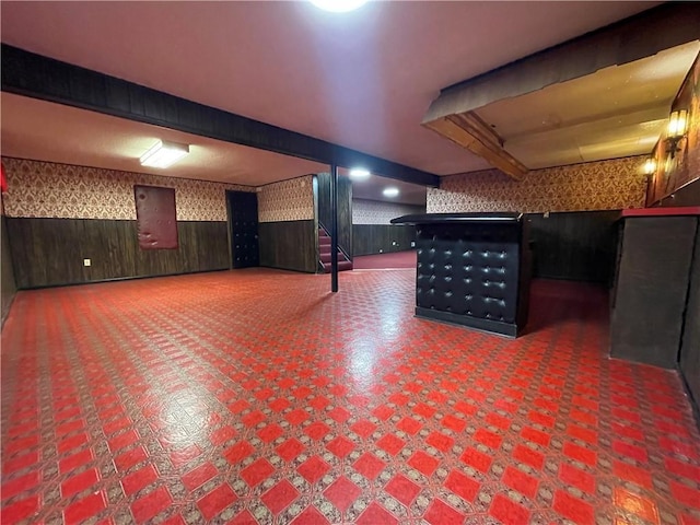 finished below grade area with wainscoting, a community bar, and wallpapered walls