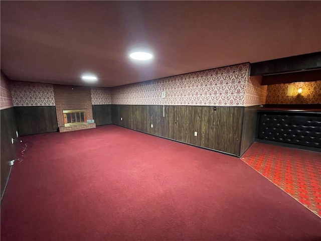 finished basement featuring carpet floors, recessed lighting, and a brick fireplace