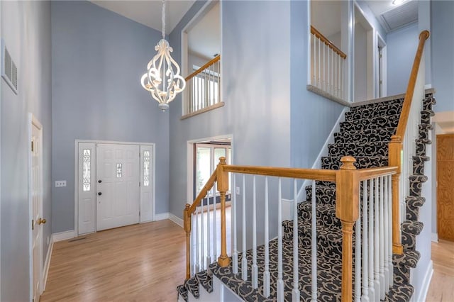 12704 Mohawk Cir, Leawood, KS 66209 - foyer entrance featuring a high ceiling, wood finished floors, a chandelier, baseboards, and stairway