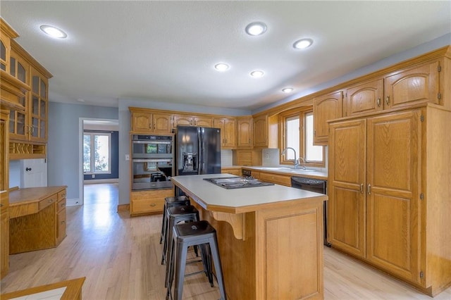 12704 Mohawk Cir, Leawood, KS 66209 - kitchen with black fridge, stovetop, a kitchen island, double oven, and plenty of natural light